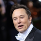 An image of Elon Musk laughing and looking at the camera at the 2022 Met Gala.